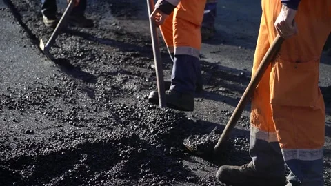 Road workers treating warm mix asphalt during road paving. Stock Footage 259056907