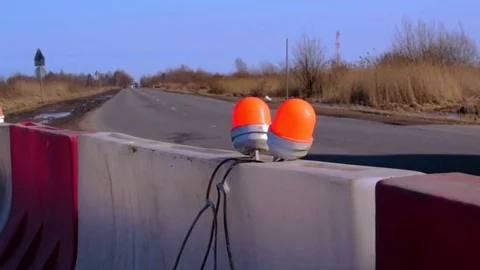 Roadblock with with orange winker and blur cars background Stock Footage 73575540
