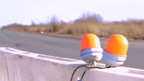 Roadblock with with orange winker and blur cars background Stock Footage 73575547