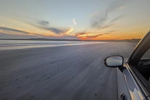 Off-Roading SUV on Sandy Beach at Sunset Backseat View Stock Photos