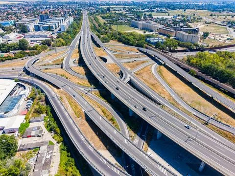 Roads intersect and connect in a busy highway system in a city. Vehicles trav Stock Photos