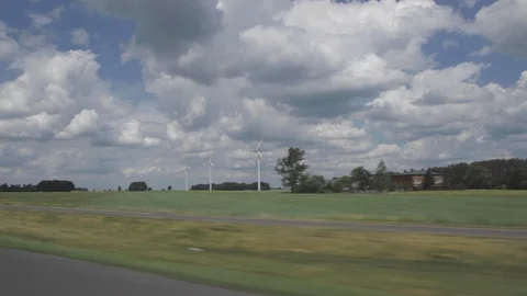 Roadside from the car on the highway with a blue sky, clouds, electric windmills Stock Footage 101264199