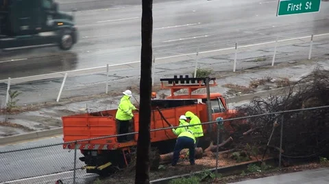 Roadside crew clearing debris from freeway during rainstorm 스톡 동영상 45295804