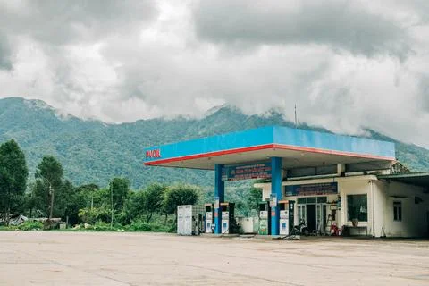Roadside fuel station beneath cloud covered mountains in a rural Vietnamese Foto stock