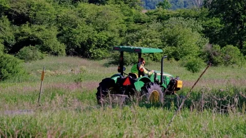 Roadside Maintenance - A Tractor With A Special Cutting Device Cutting Stock Footage 171310126