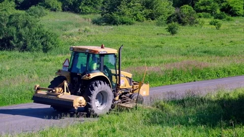Roadside Maintenance - A Tractor With A Special Cutting Device Cutting Stock Footage 171310223