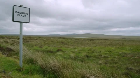A roadside passing place sign amidst the Hebridean moorland Stock Footage 332134657