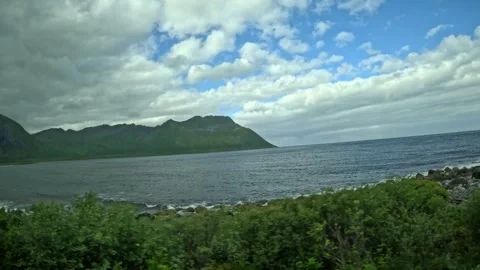 Roadside rest area, rocky beach, ocean waves, and mountains in Senja Norway Stock-Footage 342340409