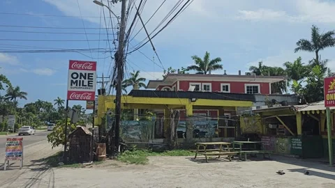 Roadside Shops With Soft Drink Signs and Power Lines, Negril, Jamaica 8K Video stock 340366524