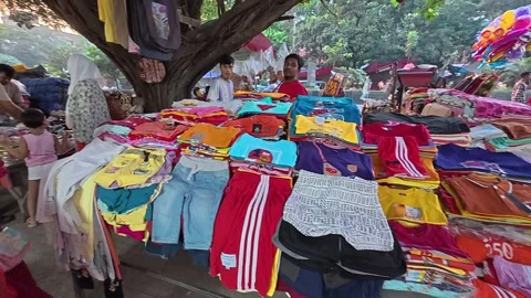 Roadside small stalls display children’s and women’s clothing for sale Stock Footage 319428939