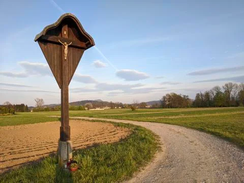 Roadside statue of Jesus next to a field Stock Photos