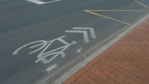 Roadway featuring worn grey bicycle lane marking on side Stock-Footage 270054716
