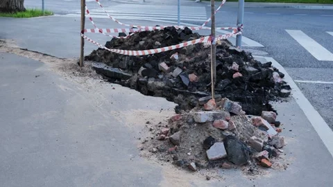 Roadwork creating hazardous conditions on sidewalk with rubble and caution tape Stock Footage 345889322