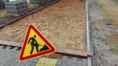 Roadworks sign. Replacing the old sidewalk road with cobblestones of cement Stock Footage 254665891