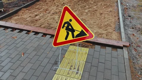 Roadworks sign. Replacing the old sidewalk road with cobblestones of cement Stock Footage 256204384