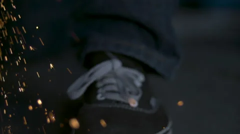 Roaming slow motion close up of soldering sparks bouncing off a sneaker. Stock Footage 64090434