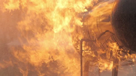 Roaring fire burns over gas tank in slow motion Stock Footage 168462207