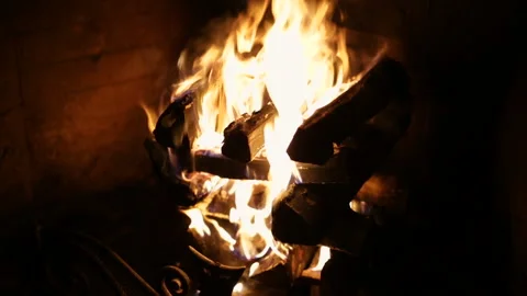 A roaring fire within a large stone arched fireplace. Stock Footage 85925207