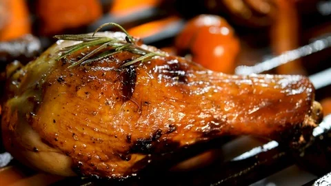 Roast bbq chicken leg with addition herbs and spices on the flaming grill . Stockbeeldmateriaal 129583401