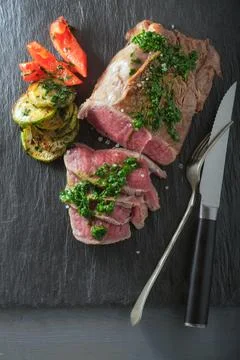 Roast Beef dinner with roasted zucchini, pepper and salsa verde Stock Photos