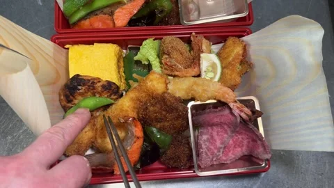 Roast Beef Lunch Box: Hands Adding Roast Beef to Finish a Japanese Bento Box Stock Footage 347052852