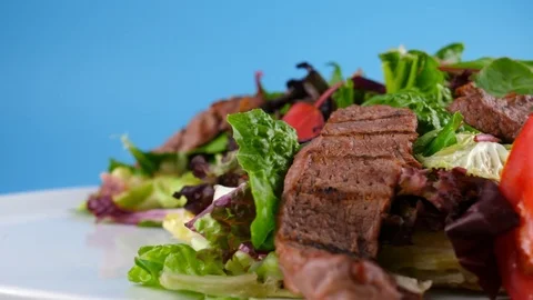 Roast beef salad with vegetables, blue background ready for chroma key Stock Footage 78700379