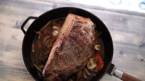 Roast beef with vegetables in a pan cools down on a wooden table Stock Footage 274902937