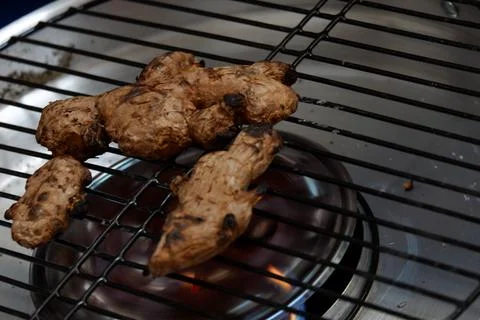 Roast the ginger before pounding it using a grill pan Stock Photos