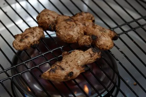 Roast the ginger before pounding it using a grill pan Stock Photos