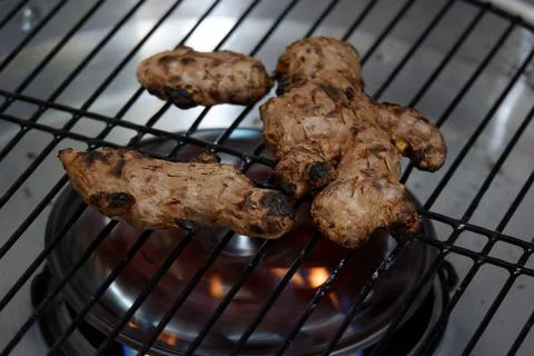 Roast the ginger before pounding it using a grill pan Stock Photos