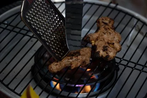 Roast the ginger before pounding it using a grill pan Stock Photos