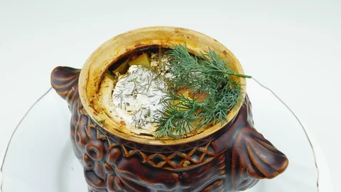 Roast at home in pots for baking.A ceramic pot on a white plate. 스톡 동영상 127734075