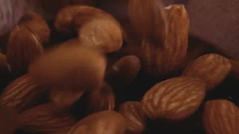Roasted almond seeds falling down into wooden bowl Stock Footage 155215702