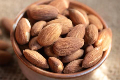 Roasted almonds in a ceramic cup.Warm tone image. Stock Photos