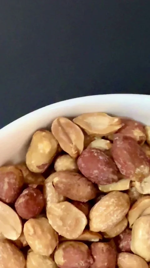 Roasted and salted peanuts served in a white bowl Video stock 331982841