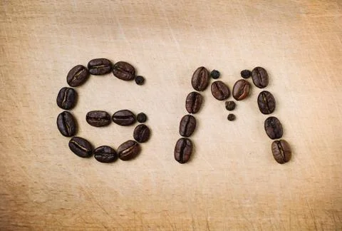 Roasted beans are set in shape of good morning combination. Stock Photos