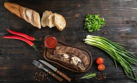 Roasted beef on the bone on a board for serving. Stock Photos