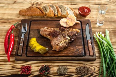 Roasted beef on the bone on a board for serving. Stock Photos