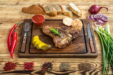 Roasted beef on the bone on a board for serving. Stock Photos