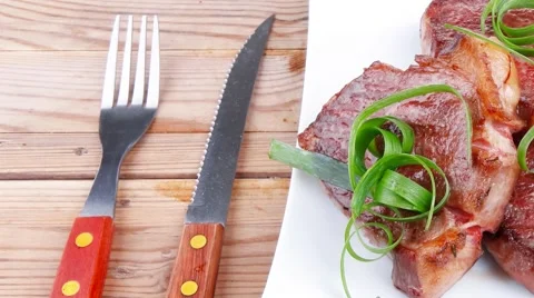 Roasted beef meat on plate over wood Stock Footage