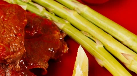 Roasted beef meat on red plate with asparagus Vídeos de archivo 50964963