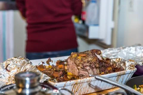 Roasted beef rib steak with bone in roasting tray on busy kitchen table Photos