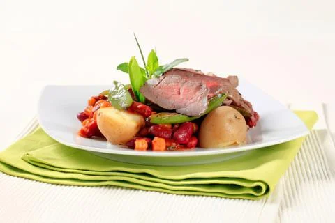 Roasted beef with vegetables on a white plate Stock Photos