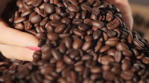 Roasted brown grains falling down on pile arabica super slow motion. Closeup Stock Footage 274627721