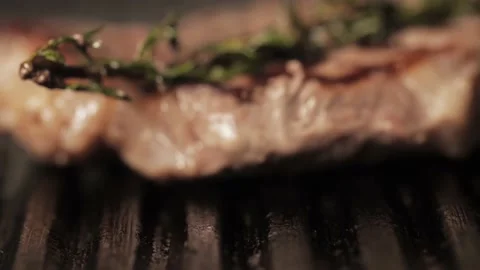 Roasted burger patty put before steak with sprig of rosemary on hot grill pan Video stock 138190821