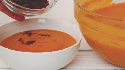 Roasted butternut squash soup. To serve soup in bowls add bacon and cream Stock Footage 290241373