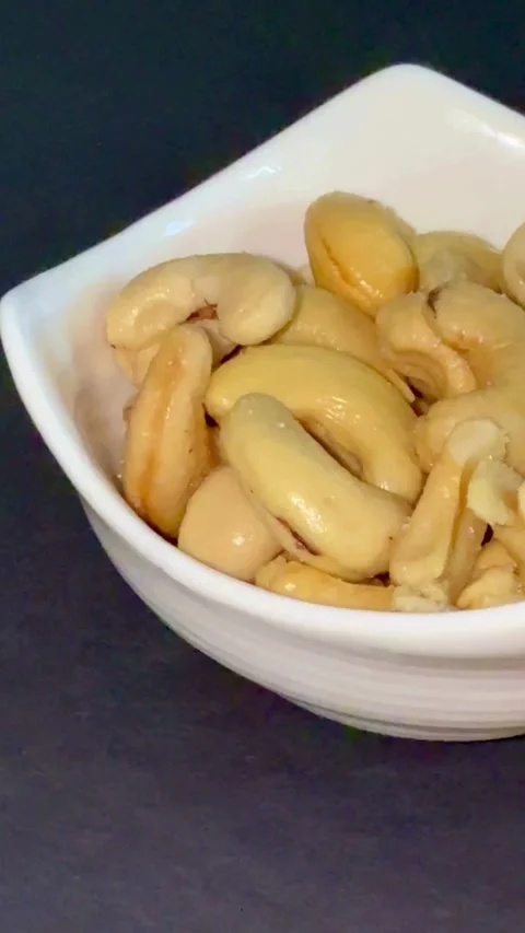 Roasted cashew nuts are served in a white bowl Stock Footage 331980183