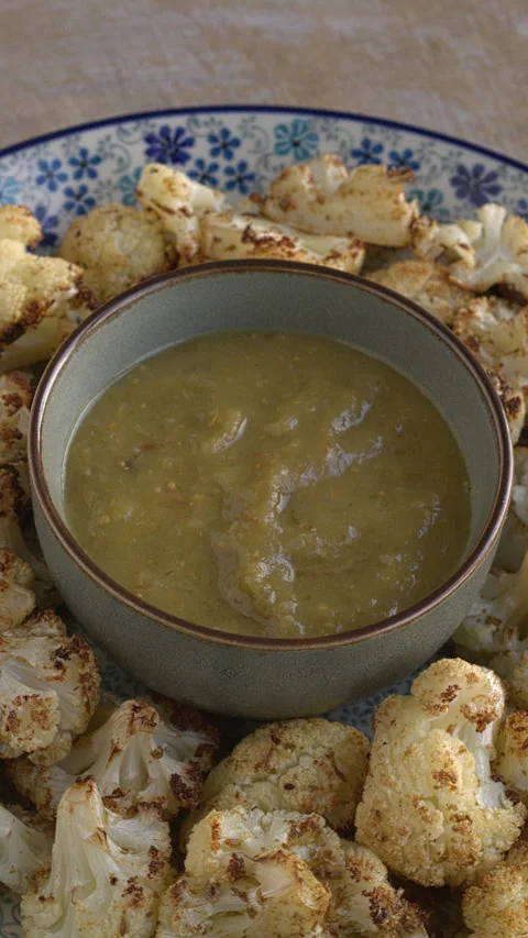 Roasted cauliflower served with tomatillo salsa. Vertical video. Video stock 277418871