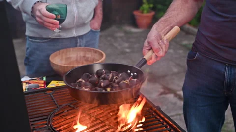 Roasted chestnuts and maroni over the fire in a special steel pan. Traditional Stock Footage 166085694