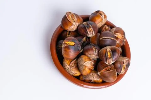 Roasted chestnuts in an earthenware casserole isolated on a white background Stock-Fotos